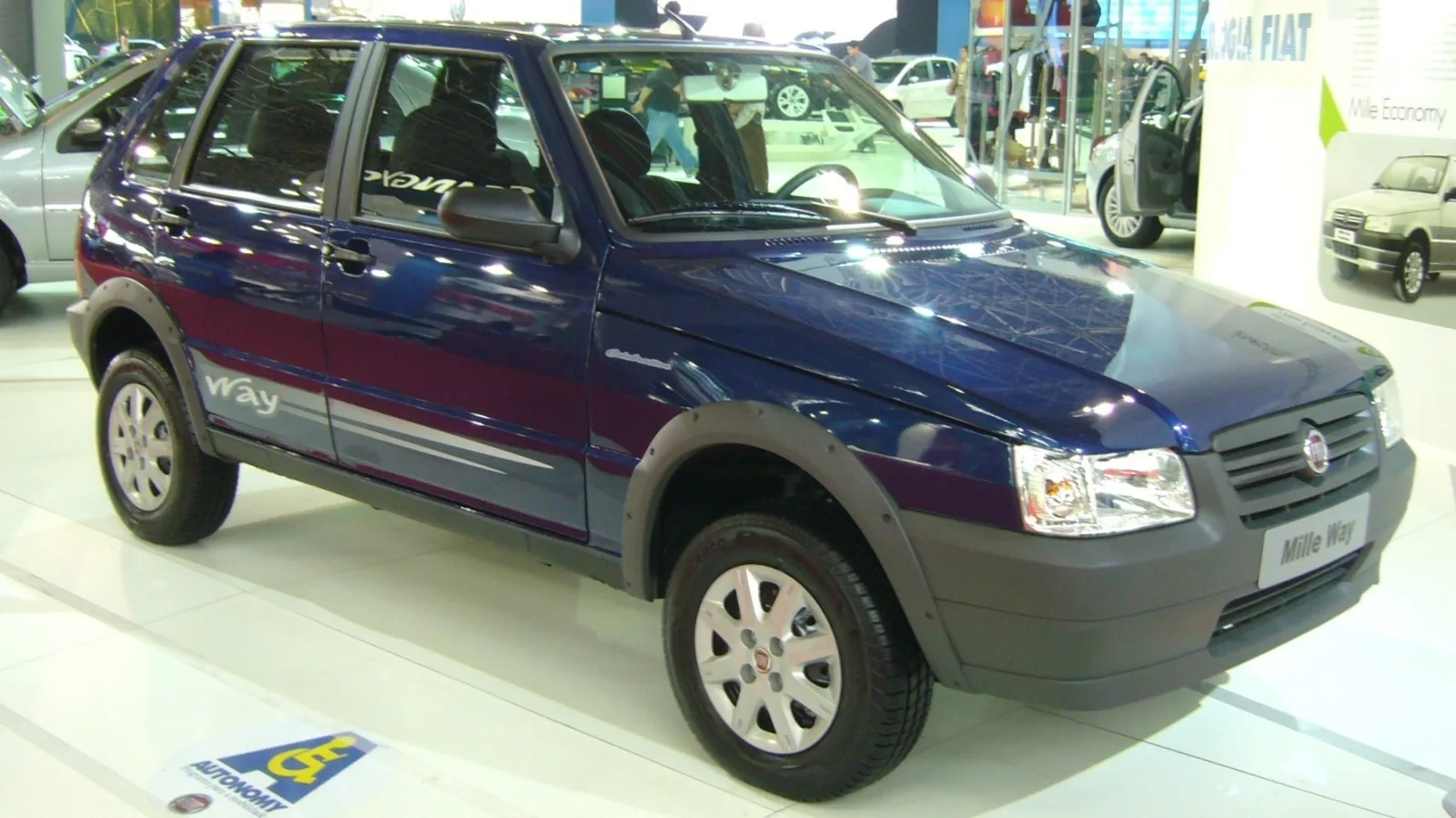 Fiat Mille Way exposto num salão de automóveis, com o Mille Economy no painel ao fundo