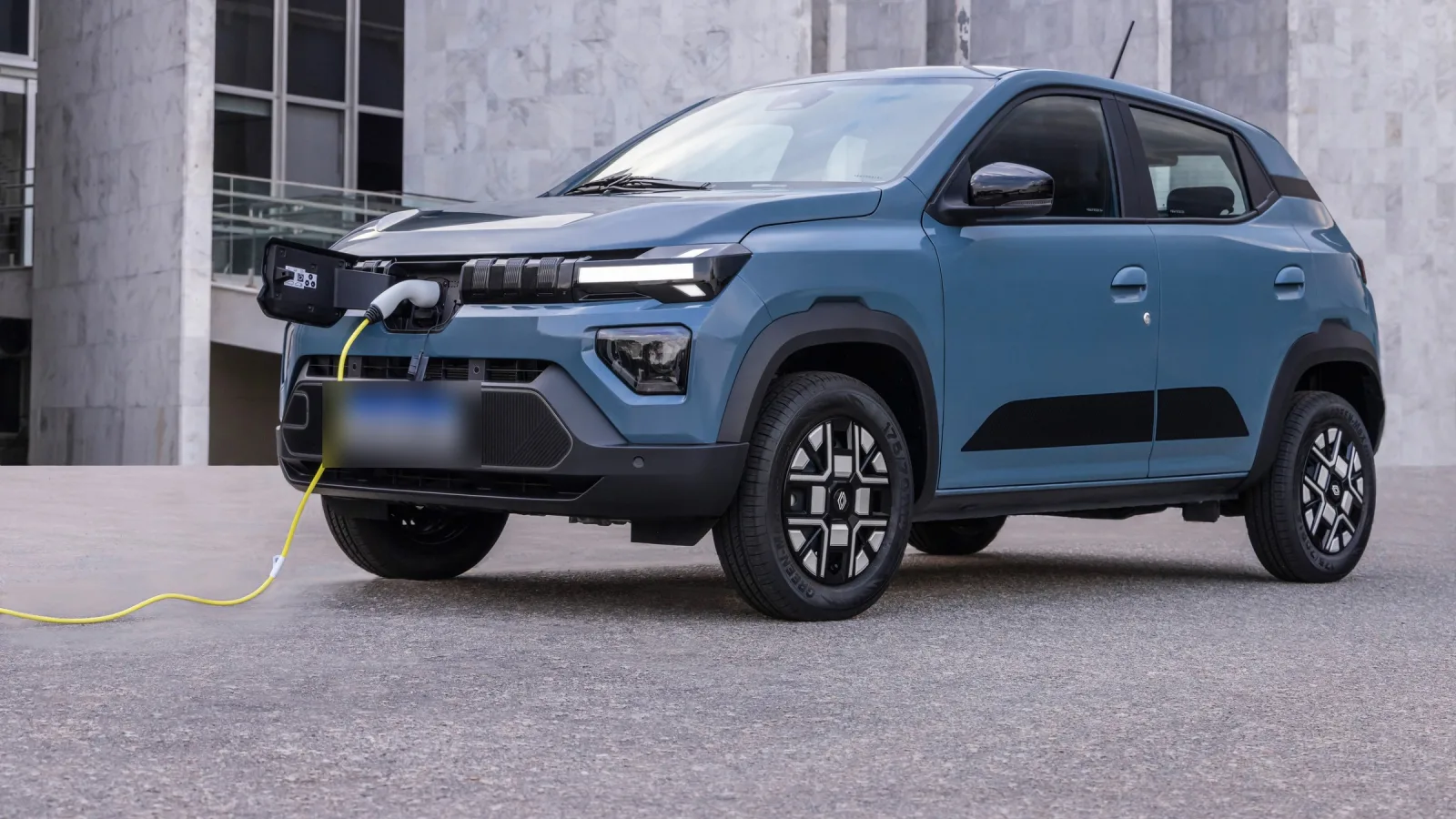 Renault Kwid E-Tech, o elétrico mais barato do país, ligado ao cabo de recarga na apresentação da linha renovada, em 2025