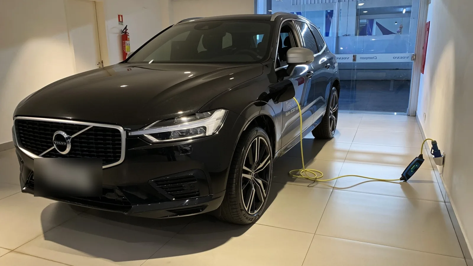 Um SUV híbrido plug-in ligado ao carregador numa concessionária de Brasília, em 2019