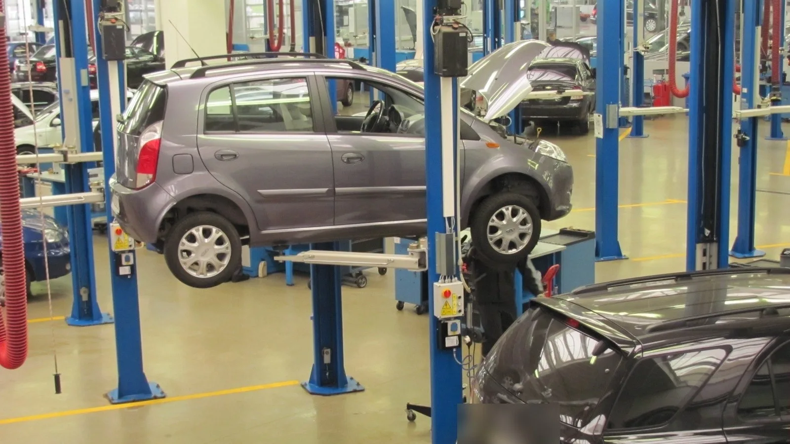 Carros nos elevadores da oficina de uma concessionária